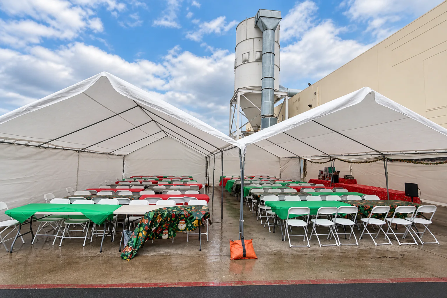 Two large white event tents filled with banquet tables and folding chairs
